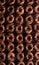 Monochrome picture of lots of chocolate homemade donuts pattern with chocholate glaze dark background