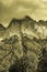 Monochrome sepia vintage style cloudy mountain landscape with trees, mist and clouds