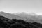 Monochrome shot of foggy mountain range layers, horizontal background