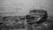 Monochrome tone of a logboat harbored at the beach covered by big rock in Toba Lake, North Sumatra, Indonesia