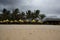 Monsoon storm tempest on the beach with palms and umbrellas.