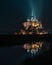 Mont-Saint-Michel by night, illuminated and reflection above the sea, France, Europe.