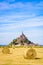 The Mont Saint-Michel tidal island in France with round bales of straw