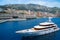 Monte Carlo, Monaco - December 08, 2009: yacht go along sea coast. Water craft and city on mountain landscape. Luxury