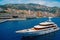 Monte Carlo, Monaco - December 08, 2009: yacht go along sea coast. Water craft and city on mountain landscape. Luxury