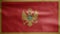 Montenegrin flag waving in the wind. Close up of Montenegro banner blowing soft silk