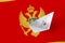 Montenegro flag depicted on paper origami ship closeup. Handmade arts concept