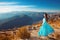 Montenegro landscape above mountain ridge and Kotor bay. Beautiful woman in blowing dress posing on the top enjoy the beauty