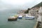 Montenegro port, wavy sea and misty weather. breakwater and small boat