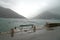 Montenegro port, wavy sea and misty weather. Old bench.