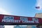 Monterey Canning Company sign on elevated bridge at Cannery Row. Flag of the United States in blue sky - Monterey, California, USA