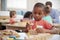 Montessori Pupil Working At Desk With Wooden Shapes