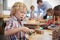 Montessori Pupil Working At Desk With Wooden Shapes