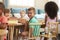 Montessori Pupil Working At Desk With Wooden Shapes