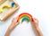 Montessori wood rainbow material. A child plays with a toy with his hands
