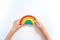 Montessori wood rainbow material. A child plays with a toy with his hands