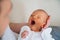 Monthly baby yawns. Father holds his head to the newborn. Small baby head in the hands of a parent close-up. Newborn baby care con