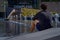 Montreal, Quebec, Canada, September 29, 2018: men with curly hair, sitting near the fountain back, in downtown Montreal