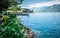 Montreux shoreline with flowers and Lake Geneva view with Alps mountains in background during sunny summer day in Montreux