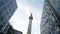 Monument on background of business buildings. Action. Bottom view of towering monument among office buildings of