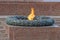 Monument eternal flame from a granite brown wall and a bronze monument around the orange flame