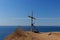 Monument in the form of a wooden cross and an old anchor, standing on a cliff on the edge of Cape Tobizin, Vladivo