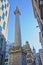 The Monument to the great fire in London surrounded by modern buildings in the financial district of the City of London with St Ma