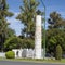 Monument to Juan Sebastian Elcano surrounded by manicured bushes, flowers and trees in Seville, Spain.