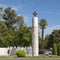 Monument to Juan Sebastian Elcano surrounded by manicured bushes, flowers and trees in Seville, Spain.