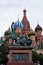Monument to Minin and Pozharsky on Red square in Moscow against green trees and walls of Saint Basil Cathedral