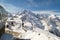 Monument to a mountain goat on the background of a ski lift and the high peaks of the Caucasus Mountains