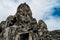 Monumental statue carved in rocks in the shape of a face on its four sides on the roof in the ruins of the Bayon temple in Ankgor