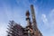 Monumental view from below of huge industrial steel mill complex, abandoned plant facility, blue sky