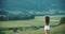 Mood of cinematography, gentle tones, alpine meadows and Austrian mountains. Cute Asian young woman with field flowers