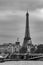 Moody cityscape with Pont Alexandre III bridge, Seine river and Eiffel Tower in Paris, France in black and white