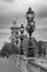 Moody cityscape with Pont Alexandre III bridge and Seine river in Paris, France in black and white