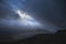 Moody and dramatic Winter landscape image of Moel Saibod from Crimpiau in Snowdonia with stunning shafts of light in stormy