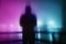 A moody hooded figure, back to camera. Silhouetted against street lights. With a vapor wave, neon artistic edit