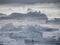 Moody layers of icebergs in mist from Greenland Arctic region