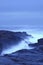 Moody Ocean Seascape landscape on rocky beach with glowing water