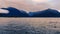 Moody weather and pink skies in the open water of Doubtful Sound