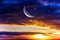 Moon in bright clouds of sunset sun . New moon