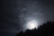 Moon halo night sky stars and blue clouds over forest