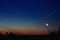 Moon and jupiter rising above the horizon at sunrise with noctilucent clouds on colorfully clouds