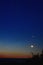 Moon and jupiter rising above the horizon at sunrise with noctilucent clouds on colorfully clouds