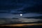 The moon obscured by clouds in the autumn evening sky