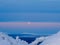 Moon partly hidden behind clouds. Part of the full moon behind the clouds. Arctic evening sky with moon