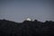 Moon rises behind mountain peaks