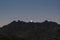 Moon rises behind mountain peaks