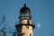 Moon rising behind a tall stone lighthouse. Montauk Point, NY